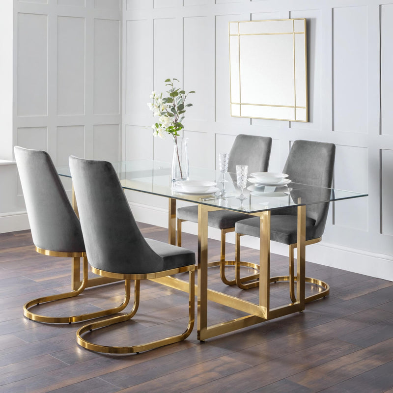 Dining room with a glass table and gray chairs on a wooden floor.