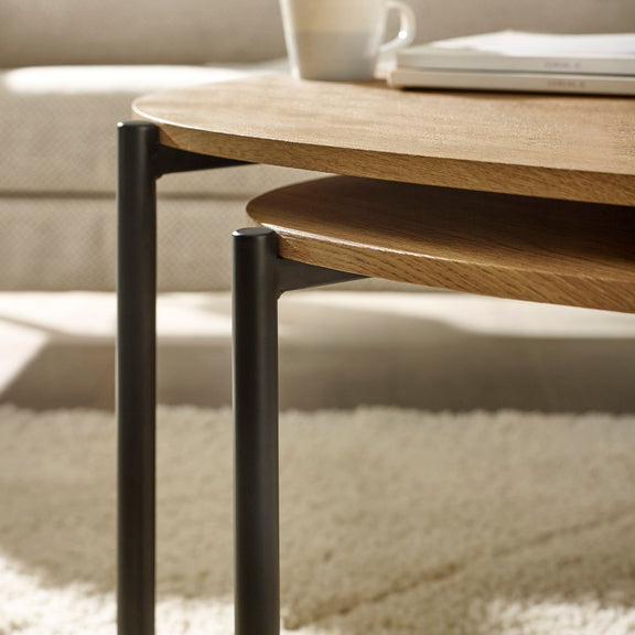 Wooden coffee table with black legs in a living room setting