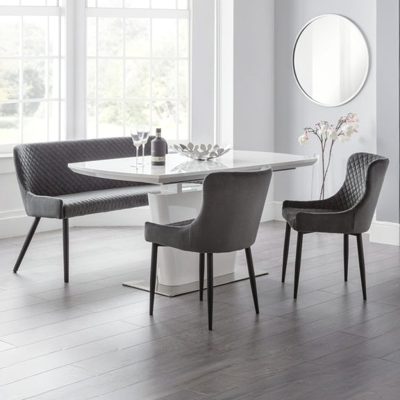 Modern dining area with a marble table, gray chairs, and a bench.