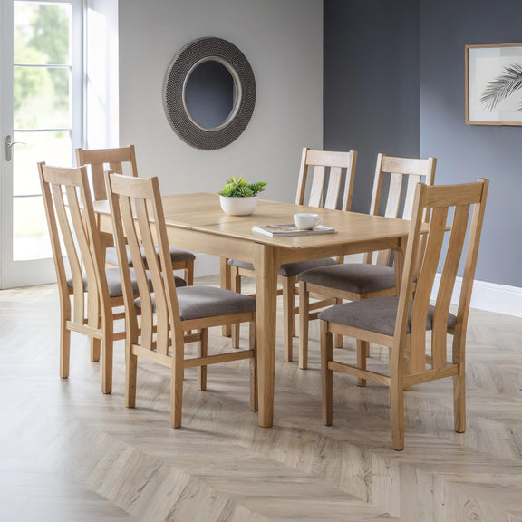 Dining room with wooden table and chairs on a wooden floor.