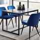 Dining table with four blue chairs in a modern interior setting.