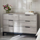 Gray dresser with floral arrangement and books on top in a room setting