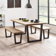 Dining table with benches in a modern room with large windows.