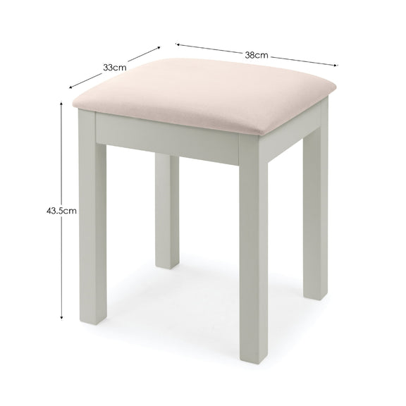 Small stool with a pink cushioned top and measurements on a white background