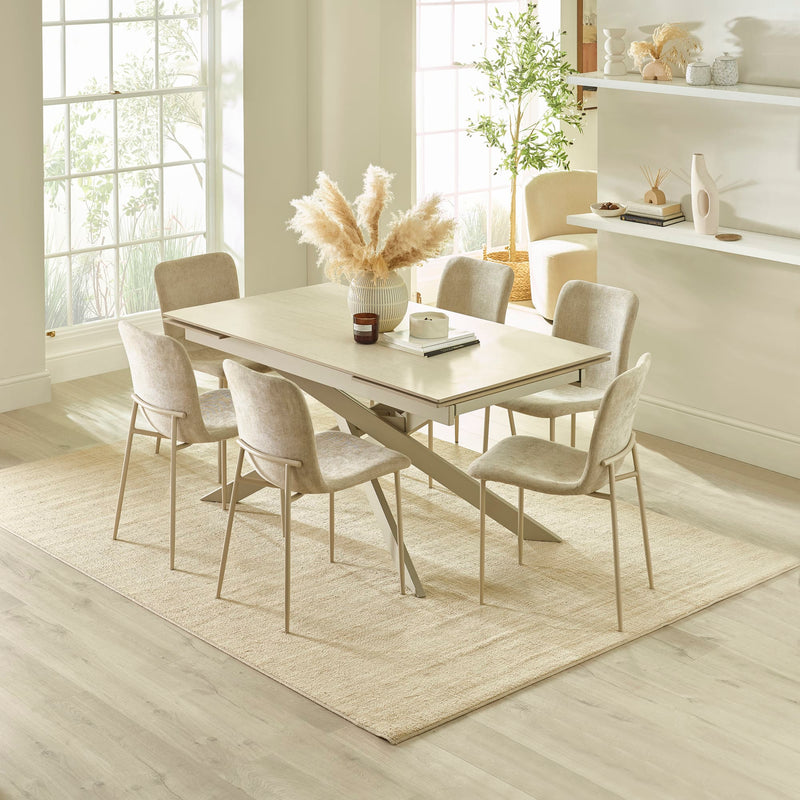 Dining room with a light wood table and chairs on a beige rug.