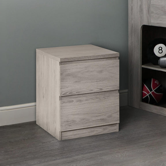 Wooden nightstand with two drawers against a gray wall.