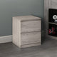 Wooden nightstand with two drawers against a gray wall.