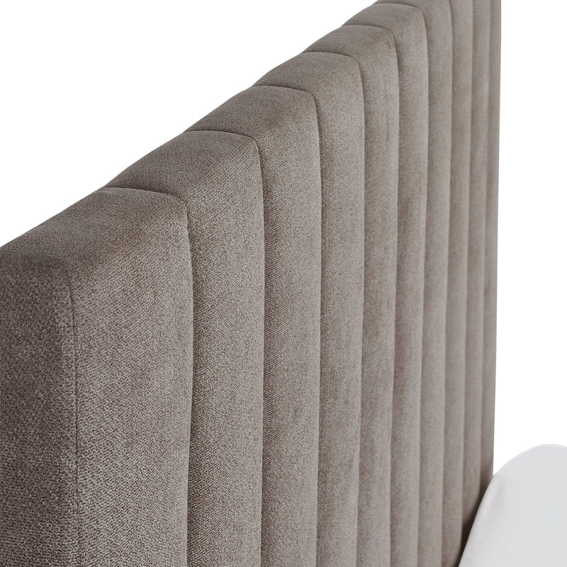 Close-up of a textured headboard with a neutral color on a white background