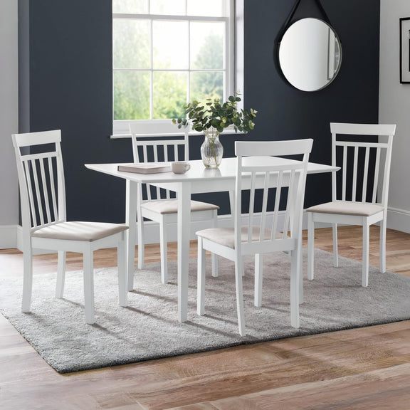 White dining set with chairs and table in a room with large windows and a mirror on the wall.