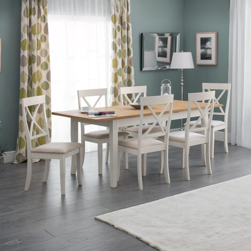 Dining room with a wooden table and white chairs against a gray wall.