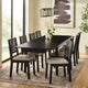 Dining room with a black table and chairs on a rug, large windows, and abstract art on the wall.