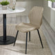 Beige chair with black legs in a room with a round table and decor items.