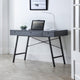 Modern black desk with a laptop and lamp in a minimalistic room.
