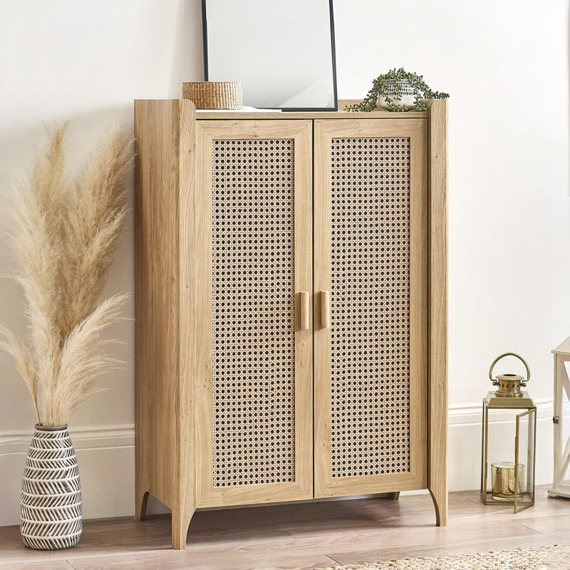 Wooden cabinet with rattan doors in a room setting with decor items.