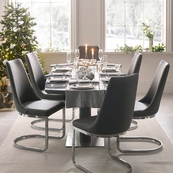 Dining table set with chairs in a modern living room with Christmas decorations.
