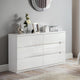 White dresser with decorative items against a gray wall