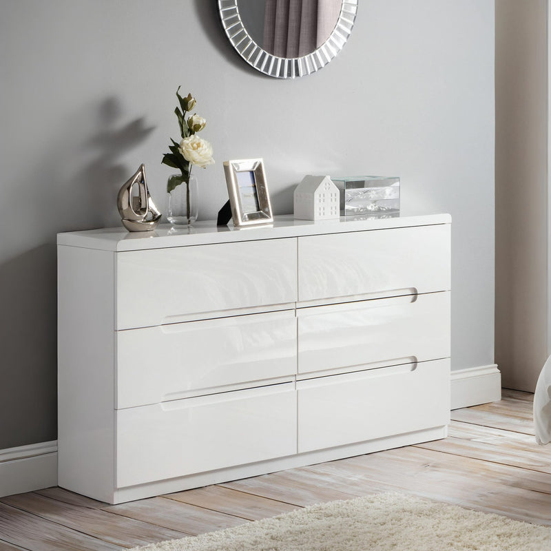 White dresser with decorative items against a gray wall
