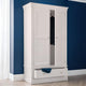 White wardrobe with a mirror against a blue wall