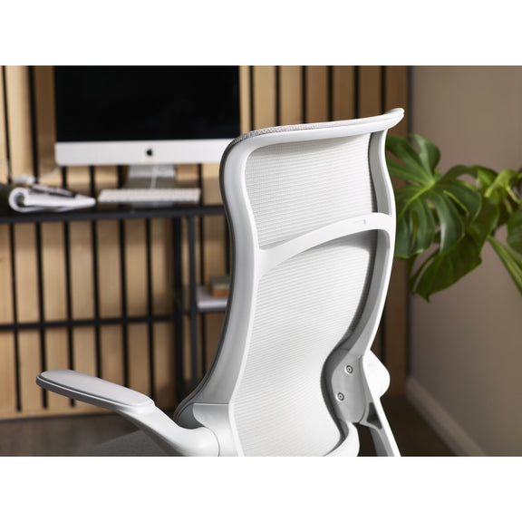 White office chair in a home office setting with a computer monitor and plant.