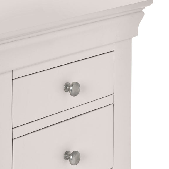 Close-up of a white cabinet with silver knobs on a white background