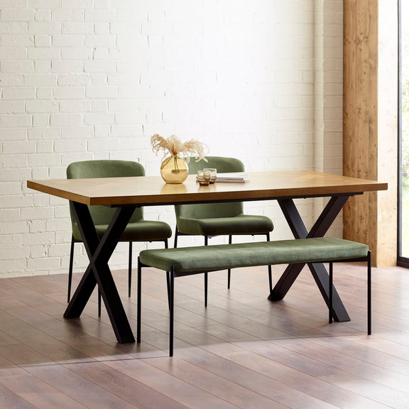 Dining set with wooden table, chairs, and bench against a white brick wall.
