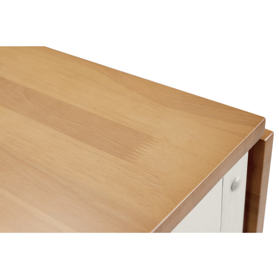 Wooden desk corner with a white cabinet in the background