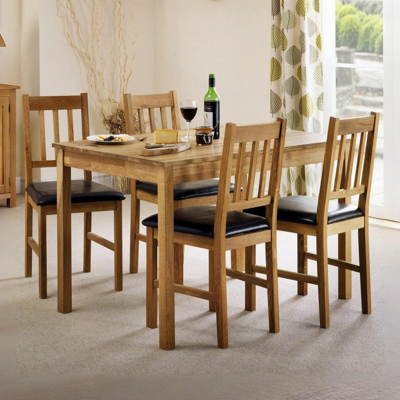 Wooden dining table with chairs in a room with a window and curtains.
