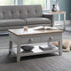 Gray sofa and coffee table with books and a bowl in a living room setting.