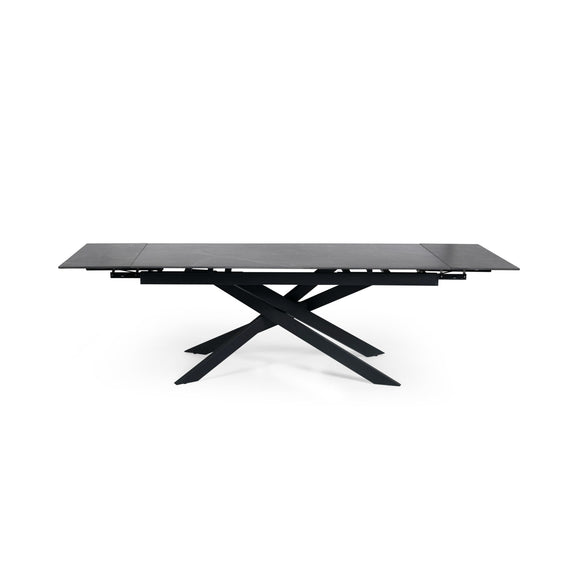 Modern dining table with black glass top and metal base on a white background