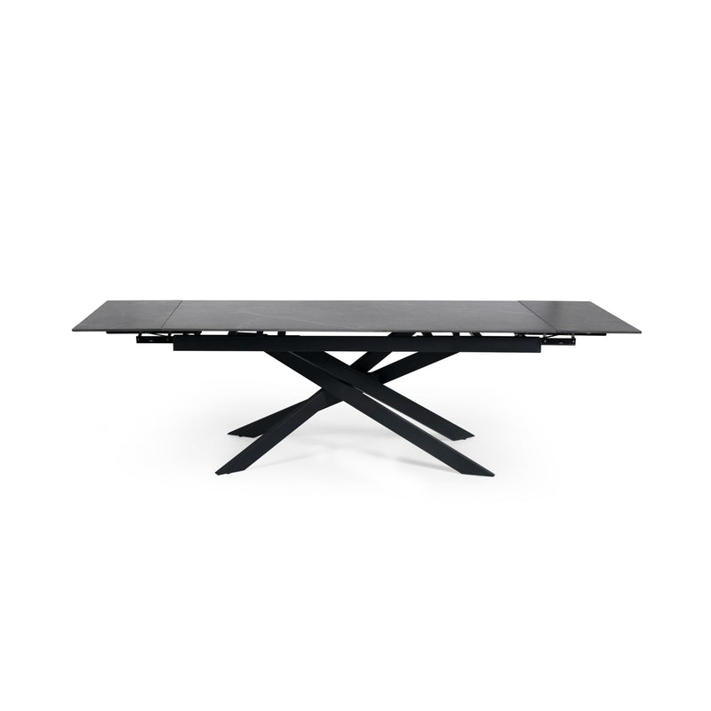 Modern dining table with black glass top and metal base on a white background