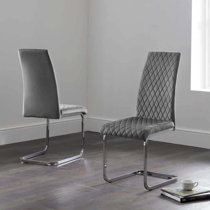Two gray chairs with quilted design on a wooden floor.