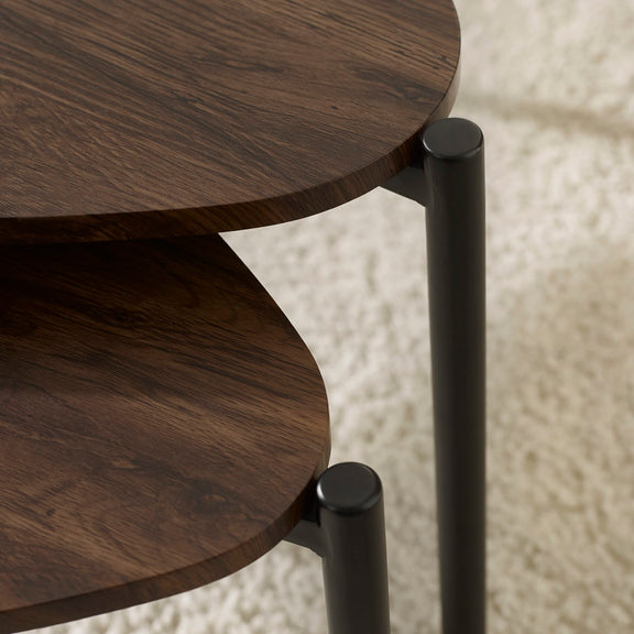 Close-up of a wooden side table with black metal legs on a textured beige background