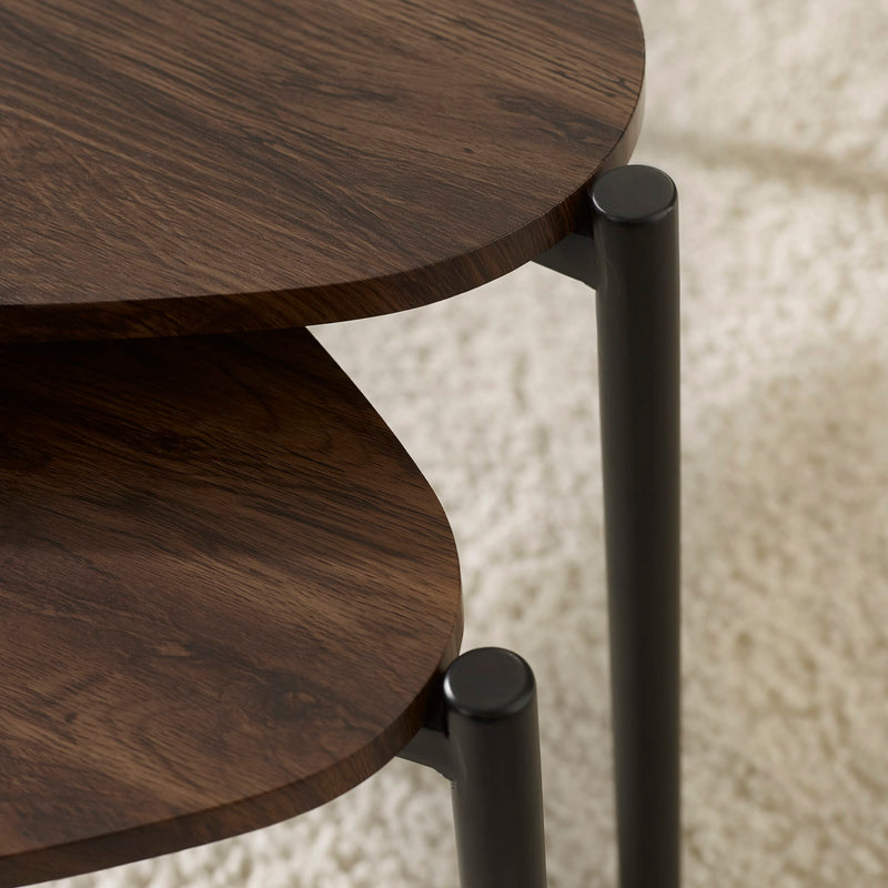 Close-up of a wooden side table with black metal legs on a textured beige background