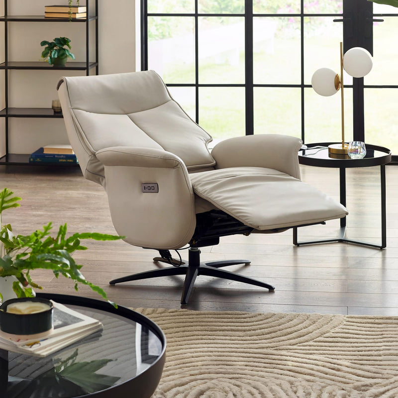 Beige recliner chair in a modern living room with large windows.