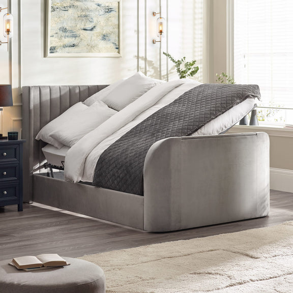 Gray upholstered bed with white bedding in a bedroom setting.