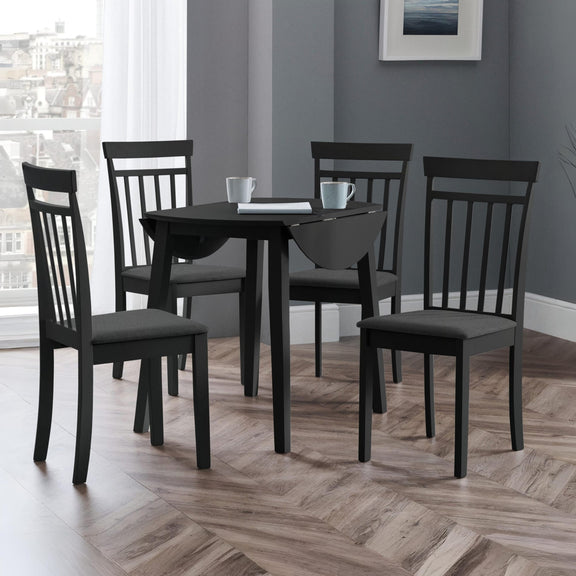 Dining room with a black table and chairs on a wooden floor.