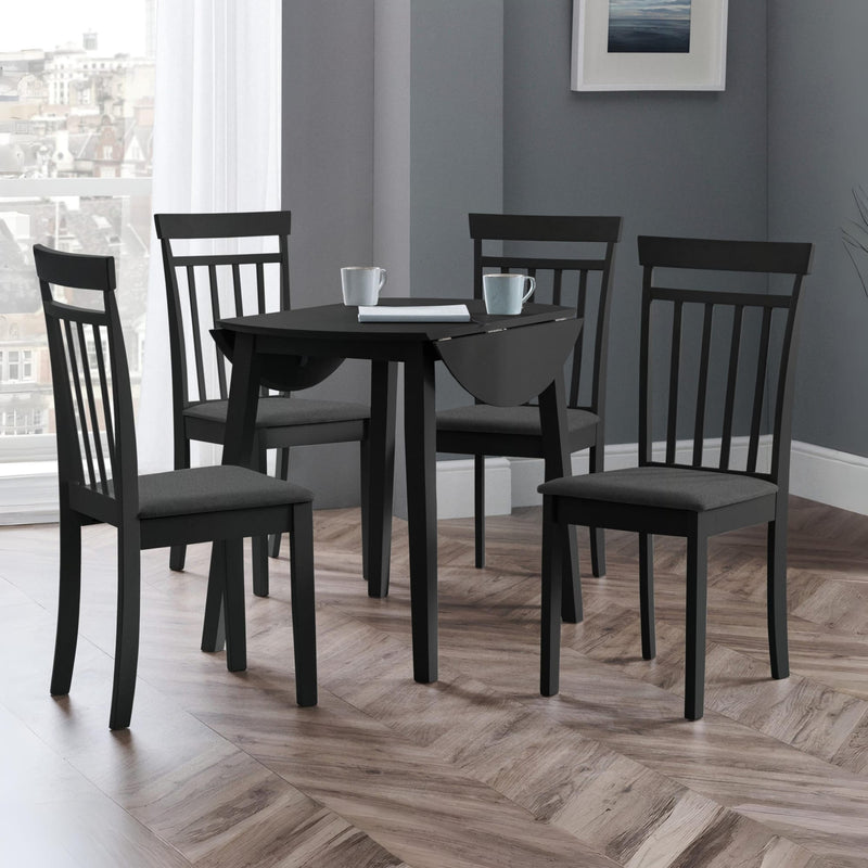 Dining room with a black table and chairs on a wooden floor.