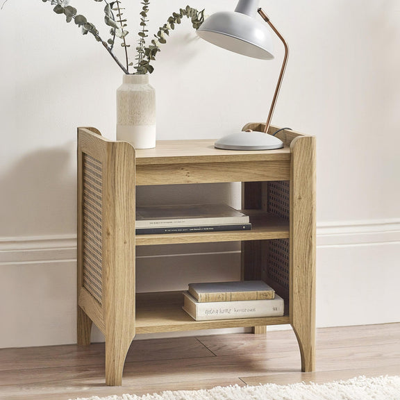 Wooden side table with books, a lamp, and a vase on a neutral background