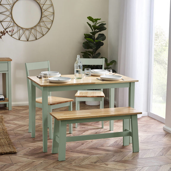 Dining room with a table, chairs, and bench on a wooden floor.