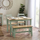 Dining room with a table, chairs, and bench on a wooden floor.