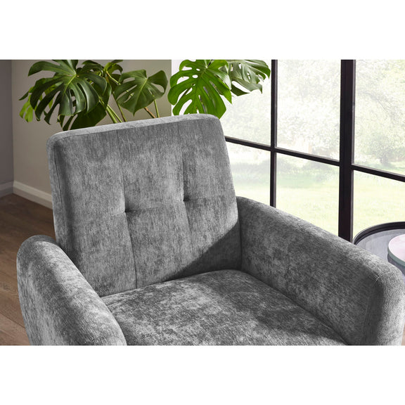 Gray armchair in a room with large windows and a plant