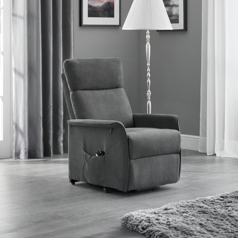 Gray recliner chair in a living room setting with curtains and a lamp.