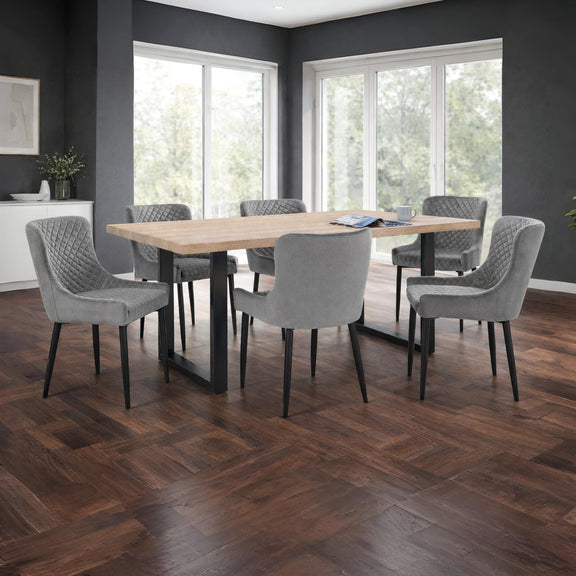 Dining room with a wooden table and gray chairs on a wooden floor.