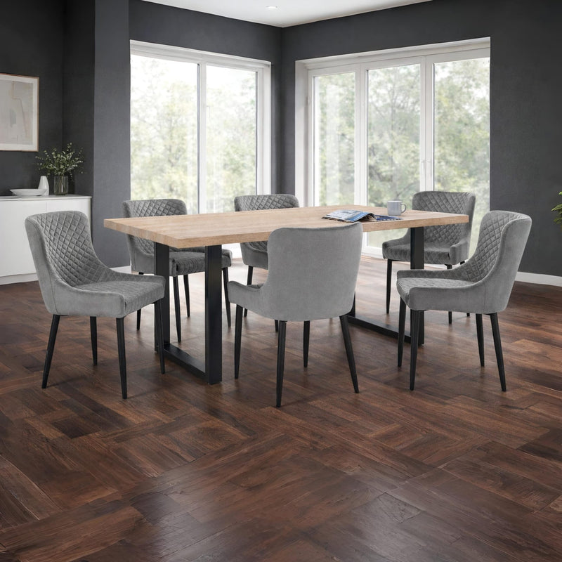 Dining room with a wooden table and gray chairs on a wooden floor.