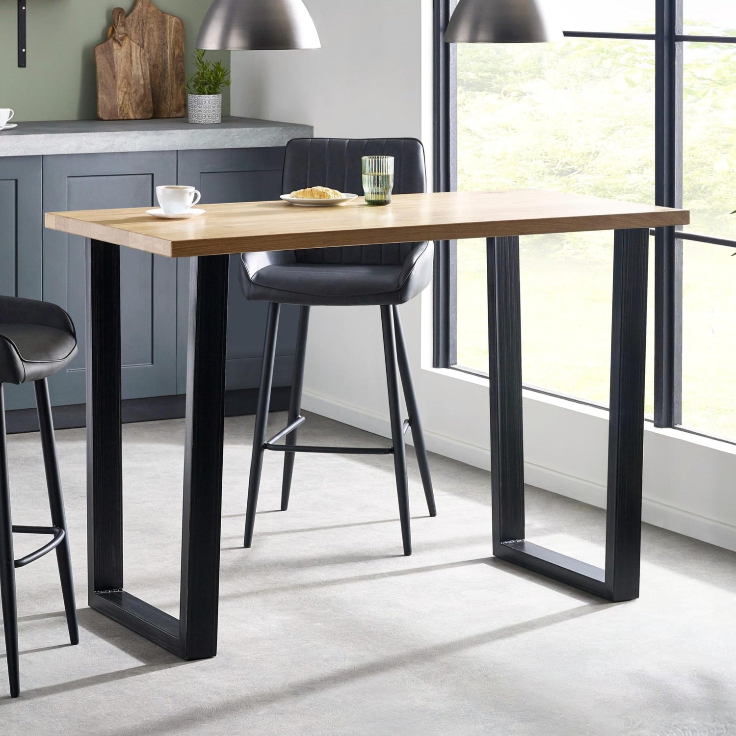 Dining table with black legs and a wooden top in a modern kitchen setting.