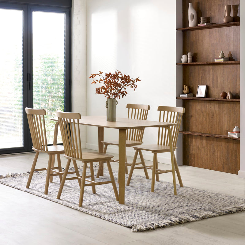 Dining room with wooden table and chairs, vase, and shelves.