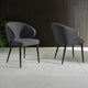 Two gray chairs on a tiled floor with a dark wooden wall in the background