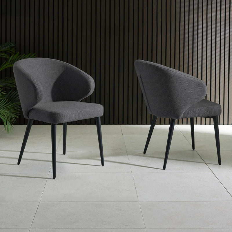 Two gray chairs on a tiled floor with a dark wooden wall in the background