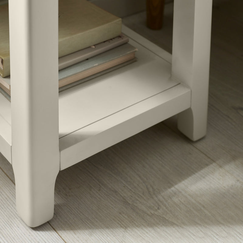 Beige side table with a glass shelf on a wooden floor