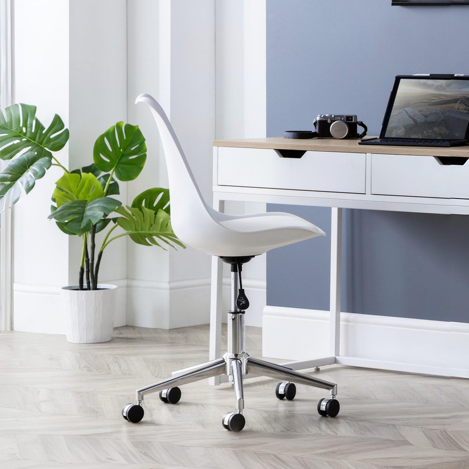 White office chair in a modern office setting with a desk and plant.